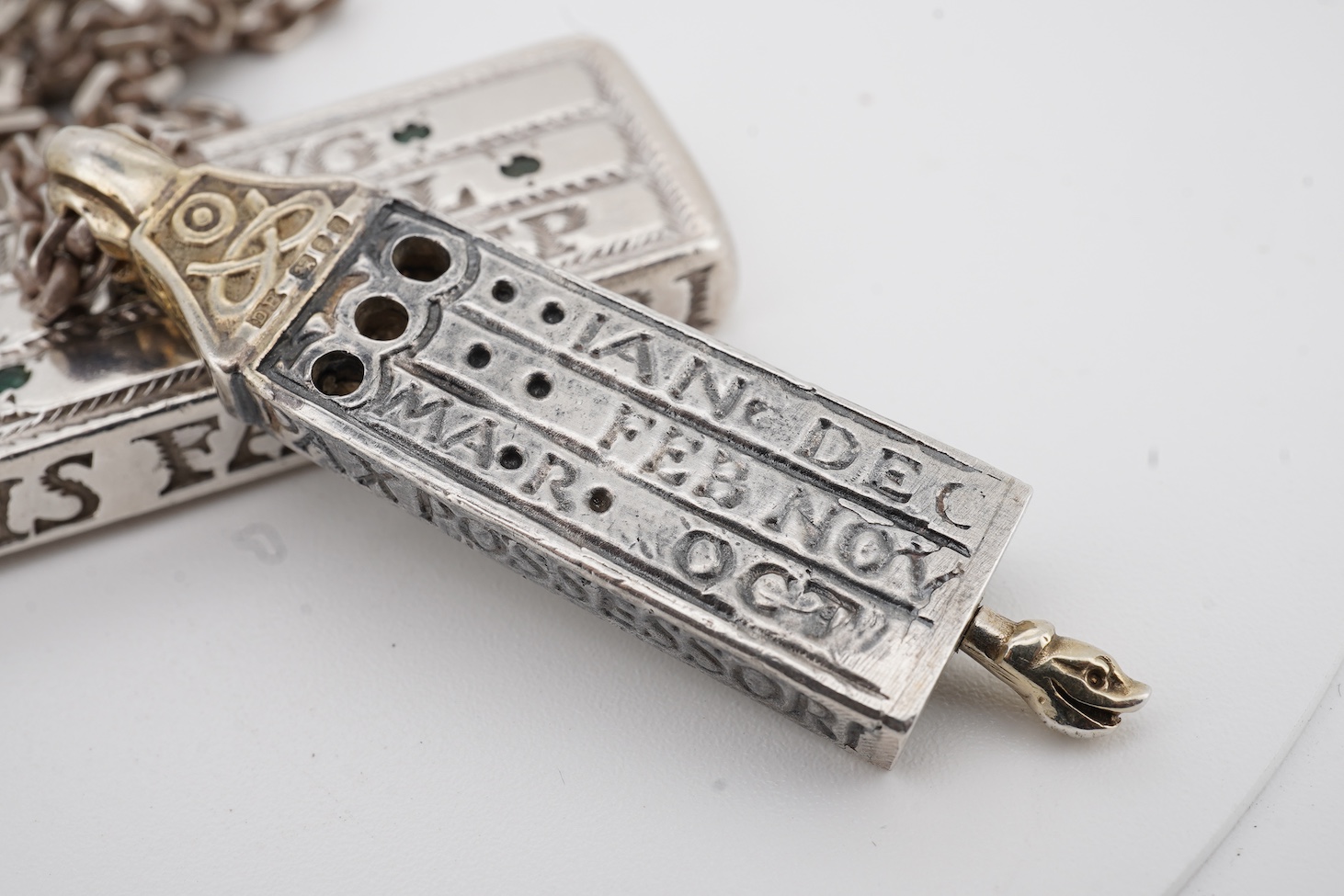 Two modern parcel gilt silver replicas of the Canterbury Pocket Sundial, the larger inset with small emeralds?, maker GF, London, 1975, the smaller later, maker DB, London, 1987, both suspended from a chain.